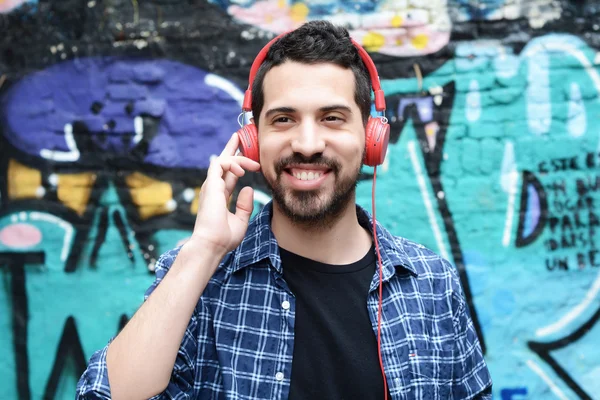 Hombre latino escuchando música con auriculares . — Foto de Stock