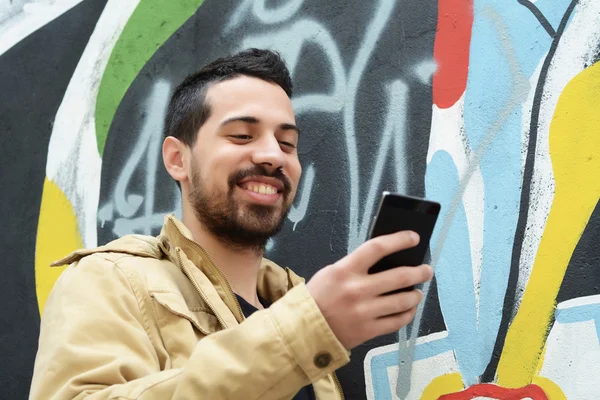 Latijnse man op zijn telefoon te typen. — Stockfoto