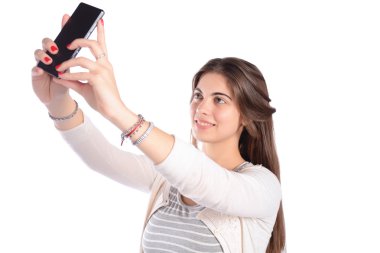 Genç bir kadın akıllı telefonuyla selfie çekiyor.