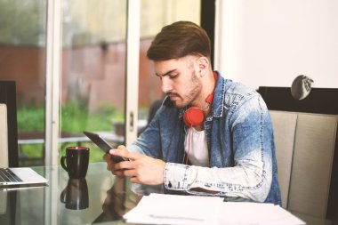 Dijital tablet kullanan genç adam.