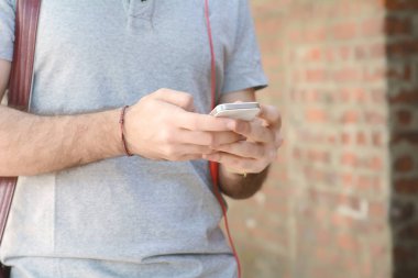 Adam onun smartphone kulaklık ile yazarak.