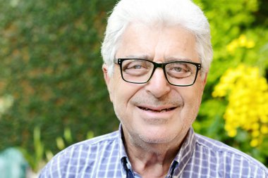 Dışında oturan yaşlı bir adam.