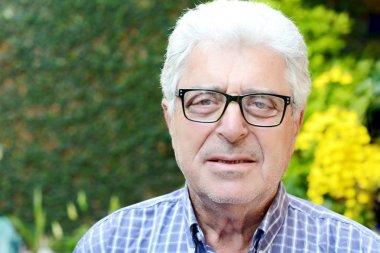 Dışında oturan yaşlı bir adam.