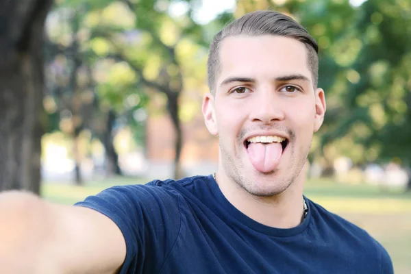 Giovane latino che si fa un selfie in un parco . — Foto Stock