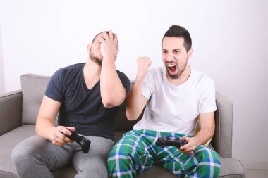 Kanepeye videogames oynarken arkadaşlar.