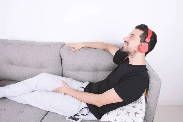 Homem ouvindo música no sofá . — Fotografia de Stock