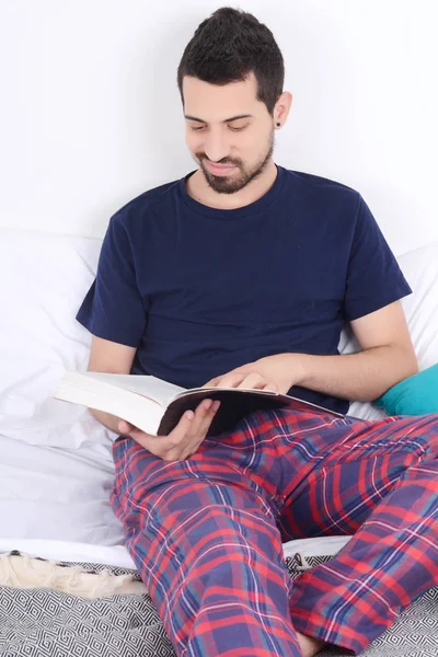 Homem lendo um livro na cama . — Fotografia de Stock