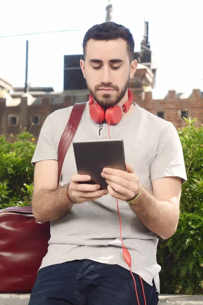 Genç adam tablet ile kulaklık kullanma.