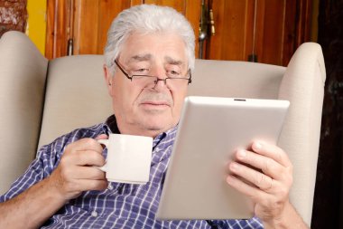 Kahve içme ve tablet kullanarak adam.