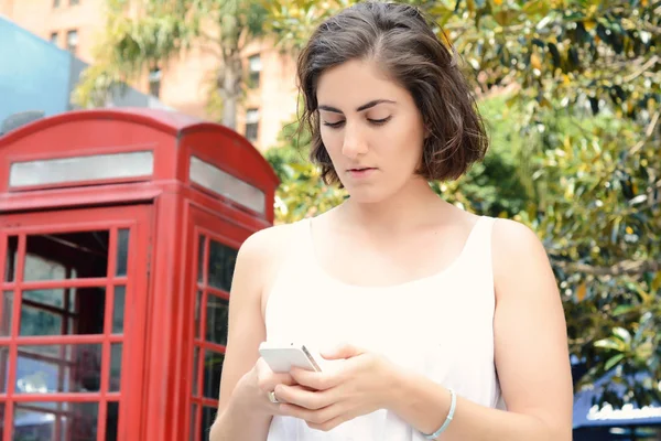 Junge Frau verschickt Nachrichten mit ihrem Smartphone. — Stockfoto