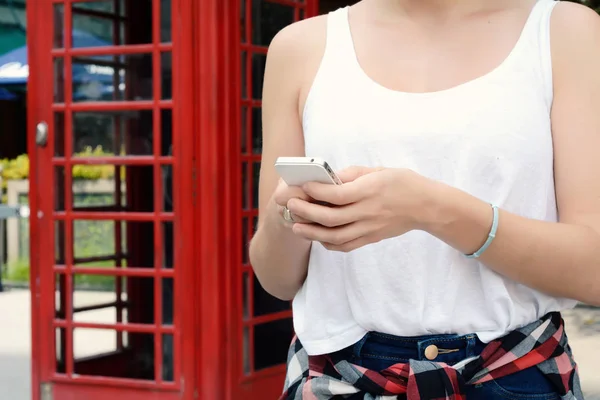 Ung kvinna skickar meddelanden med sin smartphone. — Stockfoto