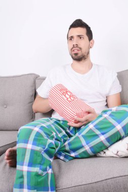 Patlamış mısır yemek ve film izlerken bir adam.