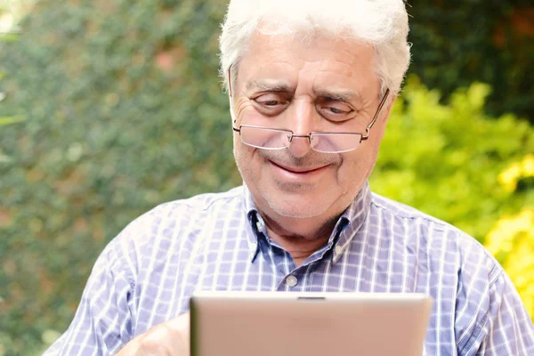 Oude man met behulp van digitale Tablet PC. — Stockfoto