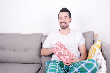 Patlamış mısır yemek ve film izlerken bir adam.