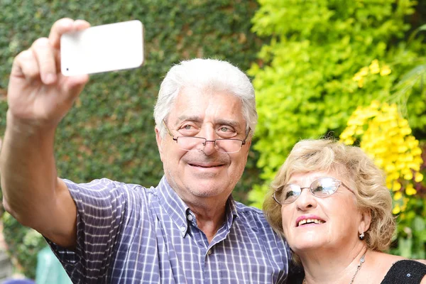 Elderly couple taking selfie with smartphone. — Stock Photo, Image