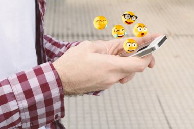 Man using smartphone sending emojis. clipart