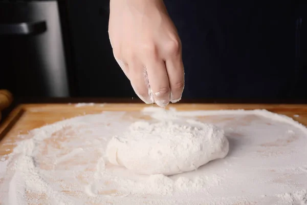 Vrouw hand bloem toe te voegen aan deeg. — Stockfoto