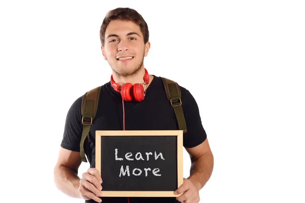 Hombre sosteniendo pizarra con "aprender más ". — Foto de Stock