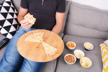 Adam kanepede pizza yeme.