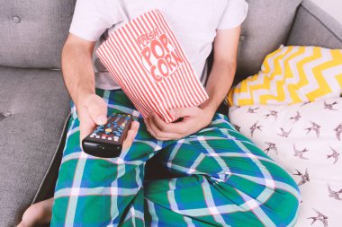 Patlamış mısır yemek ve film izlerken bir adam.