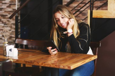 Akıllı telefon kullanan genç bir kadın.