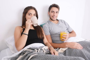 Çift yatakta kahvaltı yapıyor..