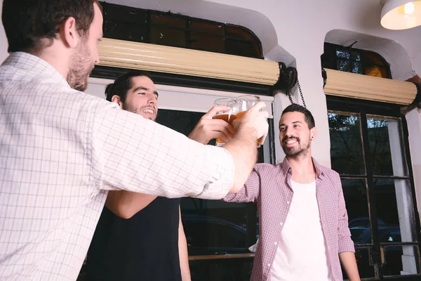 Jovens amigos clinking com cerveja — Fotografia de Stock