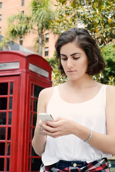 Junge Frau verschickt Nachrichten mit ihrem Smartphone. — Stockfoto