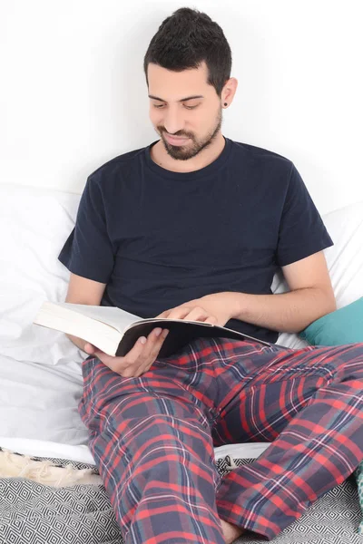 Hombre leyendo un libro en la cama . —  Fotos de Stock