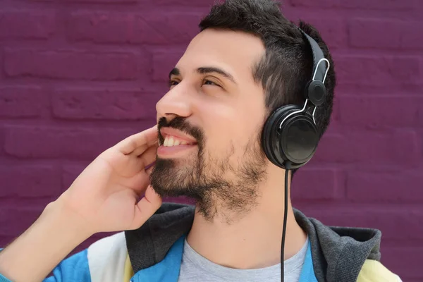 Latijnse man luisteren muziek met koptelefoon. — Stockfoto