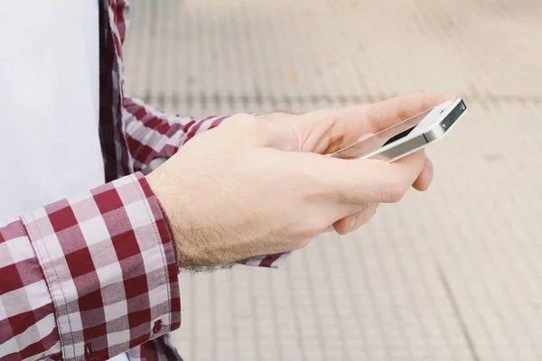 Hombre latino escribiendo en su teléfono . — Foto de Stock