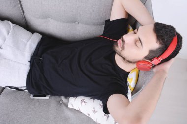 adam kanepede müzik dinleme.