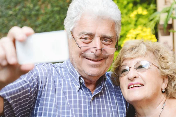 Elderly couple taking selfie with smartphone. — Stock Photo, Image