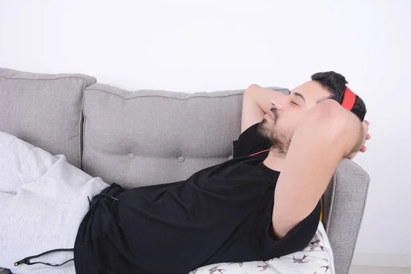 Mann hört Musik auf Couch. — Stockfoto