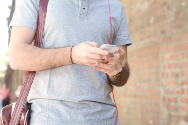 Adam onun smartphone kulaklık ile yazarak.