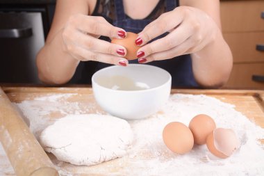 Kasenin içine bir yumurta kırma kadın.