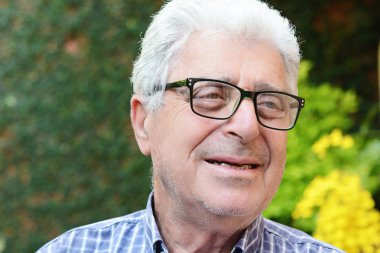 Dışında oturan yaşlı bir adam.