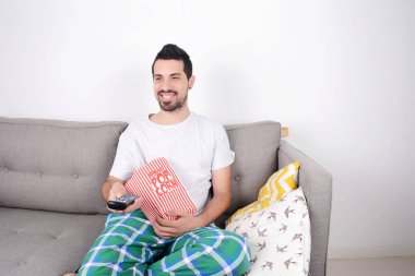 Patlamış mısır yemek ve film izlerken bir adam.