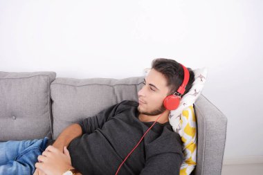 adam kanepede müzik dinleme.