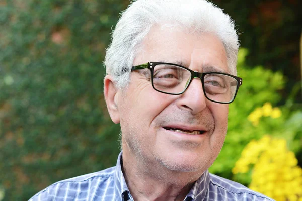 Dışında oturan yaşlı bir adam.