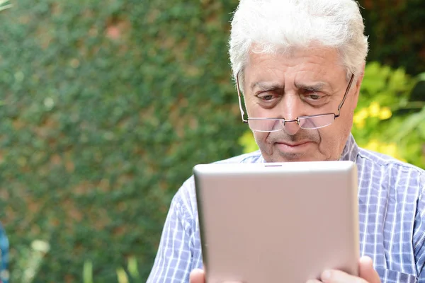 Oude man met behulp van digitale Tablet PC. — Stockfoto