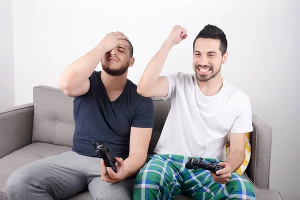 Amis jouant à des jeux vidéo sur le canapé . — Photo