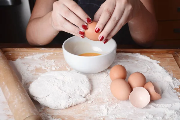 Frau bricht ein Ei in Schüssel. — Stockfoto