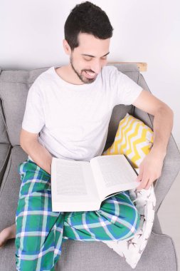 Çekici bir genç adam kanepede eğitim. 