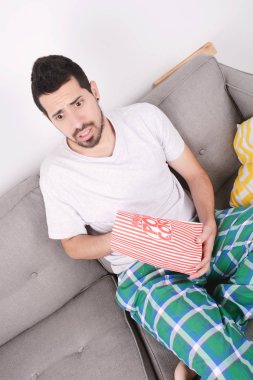 Patlamış mısır yemek ve film izlerken bir adam.