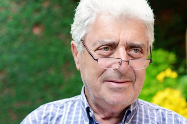 Dışında oturan yaşlı bir adam.