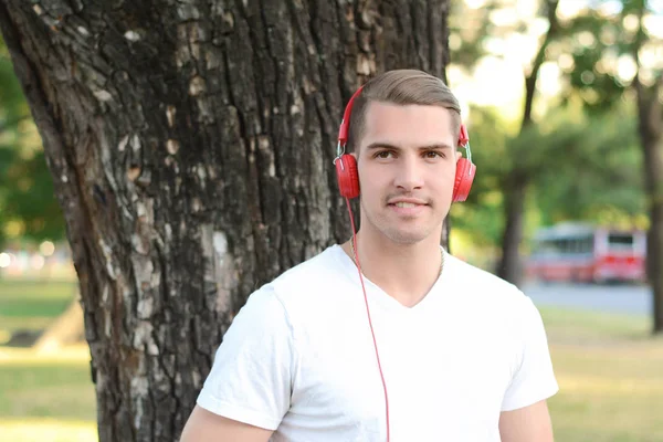 Giovane con le cuffie in un parco . — Foto Stock