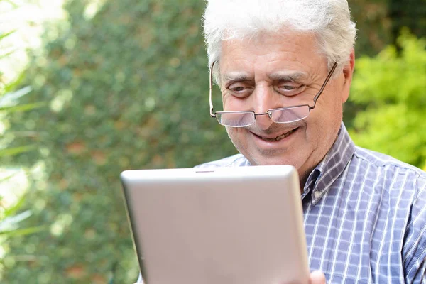 Homem velho usando tablet digital . — Fotografia de Stock