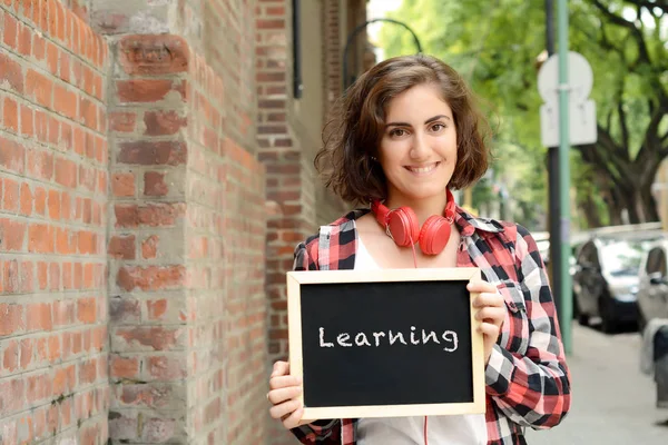 Vrouw met schoolbord met "leren". — Stockfoto