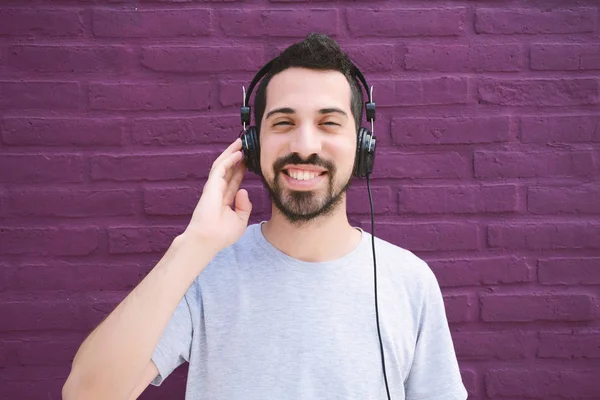 Homem latino ouvindo música com fones de ouvido . — Fotografia de Stock